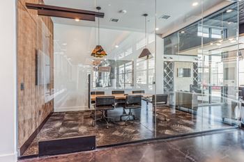 A conference room with glass walls and a table and chairs